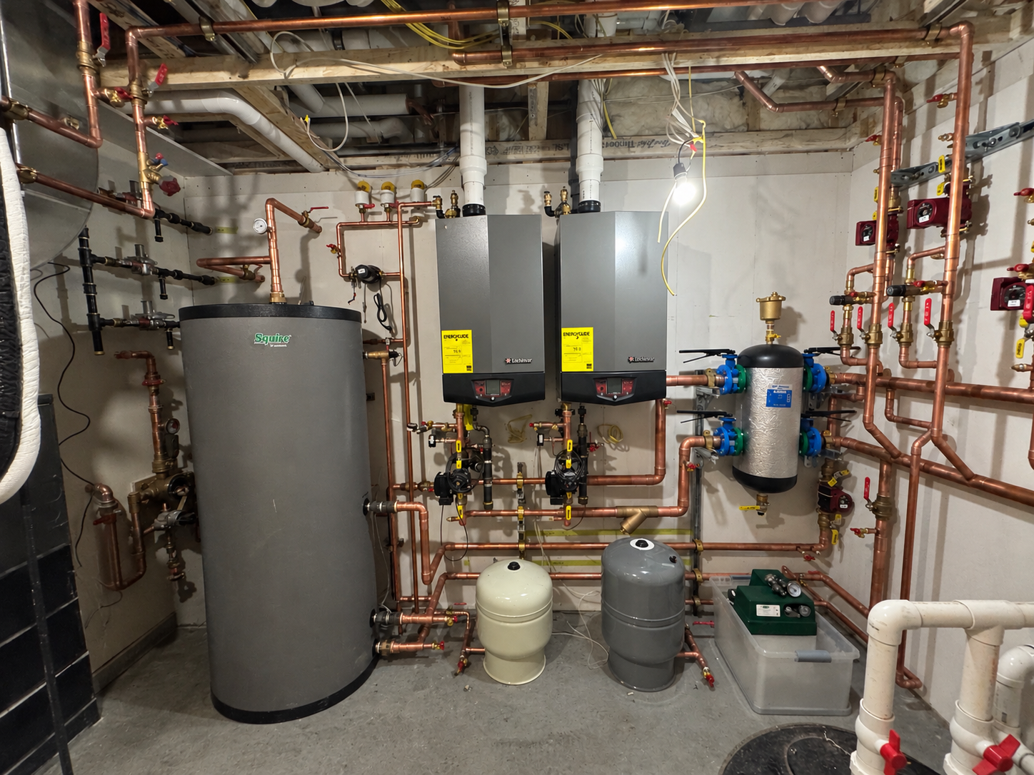 Mechanical room installation with copper piping, boilers, and hydronic equipment
